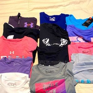 Lot of 13 girls under armour shirts.